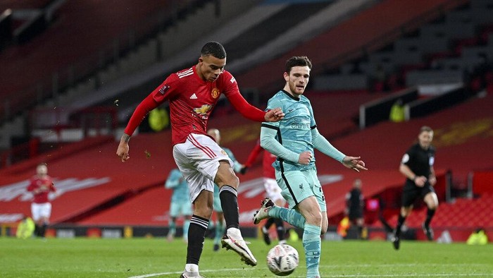 Manchester Uniteds Mason Greenwood, left, scores his sides first goal during the English FA Cup 4th round soccer match between Manchester United and Liverpool at Old Trafford in Manchester, England, Sunday, Jan. 24, 2021. (Laurence Griffiths/Pool via AP)