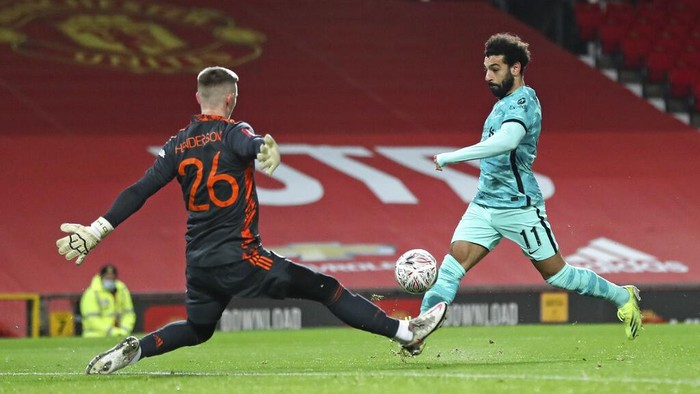 Liverpools Mohamed Salah scores the opening goal past Manchester Uniteds goalkeeper Dean Henderson during the English FA Cup 4th round soccer match between Manchester United and Liverpool at Old Trafford in Manchester, England, Sunday, Jan. 24, 2021. (Martin Rickett/Pool via AP)