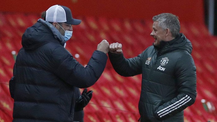 Liverpools manager Jurgen Klopp, left and Manchester Uniteds manager Ole Gunnar Solskjaer bumps fists just prior to kick off for the English FA Cup 4th round soccer match between Manchester United and Liverpool at Old Trafford in Manchester, England, Sunday, Jan. 24, 2021. (Phil Noble/Pool via AP)