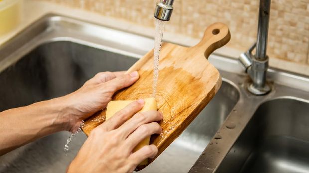 Cleaning wood cutting board in kitchen sink
