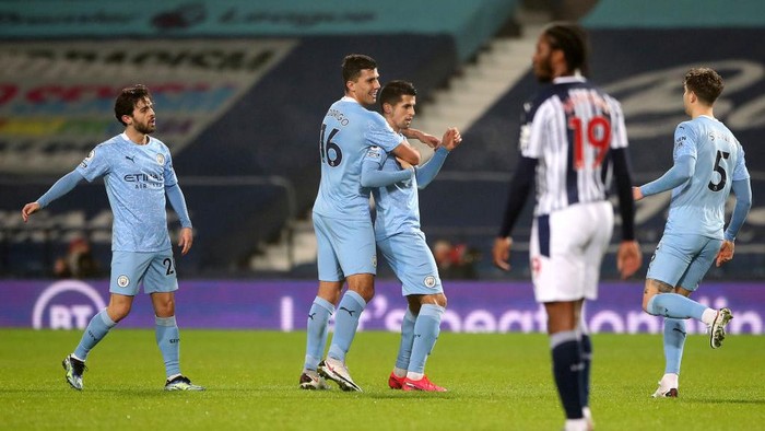 WEST BROMWICH, ENGLAND - JANUARY 26: Joao Cancelo of Manchester City celebrates with team mates Rodri after scoring their teams second goal during the Premier League match between West Bromwich Albion and Manchester City at The Hawthorns on January 26, 2021 in West Bromwich, England. Sporting stadiums around the UK remain under strict restrictions due to the Coronavirus Pandemic as Government social distancing laws prohibit fans inside venues resulting in games being played behind closed doors. (Photo by Nick Potts - Pool/Getty Images)