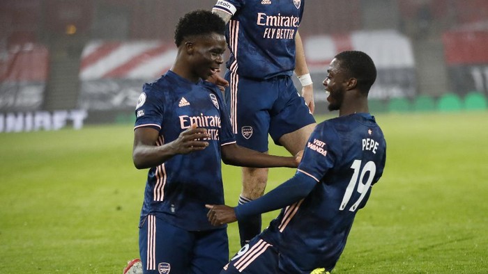 Arsenals Bukayo Saka, left, celebrates with Arsenals Nicolas Pepe after scoring his sides second goal during an English Premier League soccer match between Southampton and Arsenal at the St Marys stadium in Southampton, England, Tuesday Jan. 26, 2021. (AP Photo/Frank Augstein, Pool)
