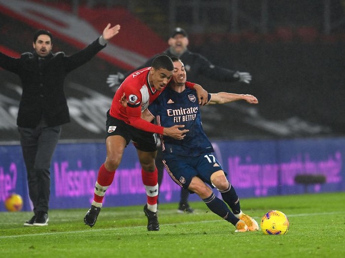 SOUTHAMPTON, ENGLAND - JANUARY 26: Yan Valery of Southampton is challenged by Cedric Soares of Arsenal as Mikel Arteta, Manager of Arsenal and Ralph Hasenhuttl, Manager of Southampton react during the Premier League match between Southampton and Arsenal at St Marys Stadium on January 26, 2021 in Southampton, England. Sporting stadiums around the UK remain under strict restrictions due to the Coronavirus Pandemic as Government social distancing laws prohibit fans inside venues resulting in games being played behind closed doors. (Photo by Andy Rain - Pool/Getty Images)
