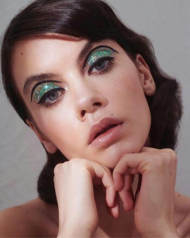 Emerald lids dengan aksen eyeliner hitam menciptakan getaran tahun 1960-an.