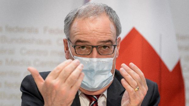 Swiss President Guy Parmelin (L) gives a press conference on new measures to control the spread of the Covid-19 pandemic caused by the novel coronavirus, on January 13, 2021 in Bern. (Photo by Fabrice COFFRINI / AFP)