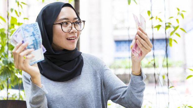 Malaysian Girl wearing hijab, rejoicing her first salary and counting cash, woman money