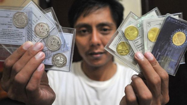 TO GO WITH INDONESIA-RELIGION-ISLAM-GOLD-ECONOMY FEATURE BY PRESI MANDARI 
Photograph taken on January 27, 2010 shows Sofyan, an Indonesian moneychanger displaying silver dirham and gold dinar coins used in the daily transaction at Cilincing district in north Jakarta.  Guided by a Scottish-born convert to Islam, a group of devout Indonesian Muslims is shunning 