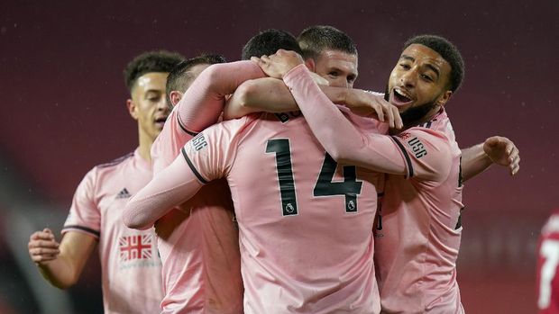 Sheffield United's Oliver Burke, 14, is congratulated by teammates after scoring his team's second goal during the English Premier League soccer match between Manchester United and Sheffield United at Old Trafford, Manchester, England, Wednesday, Jan. 27, 2021. (AP Photo/Tim Keeton,Pool)