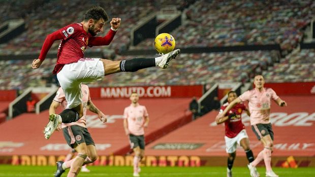 Manchester United's Bruno Fernandes is airborne as he kicks the ball during the English Premier League soccer match between Manchester United and Sheffield United at Old Trafford, Manchester, England, Wednesday, Jan. 27, 2021. (AP Photo/Tim Keeton,Pool)