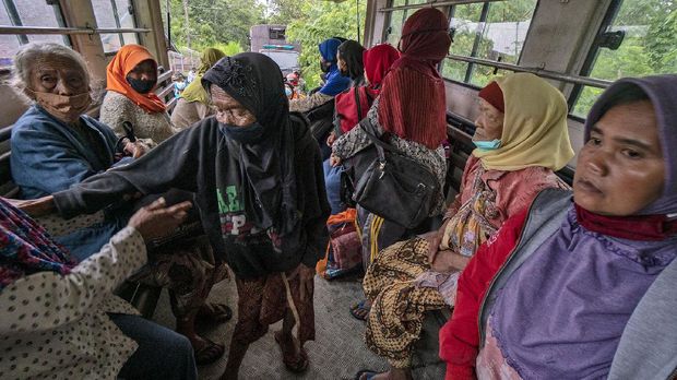 Indonesian people board a truck to evacuate their homes following the eruption of Mount Merapi in Sleman, Yogyakarta, Indonesia, Wednesday, Jan. 27, 2021. Dozens of people, mostly elderly, living within a few kilometers of the crater of the country's most active volcano were evacuated to barracks set up for displaced people after it erupted Wednesday with a river of lava and searing gas clouds flowing down its slopes. No casualties were reported. (AP Photo/Kasan Kurdi)