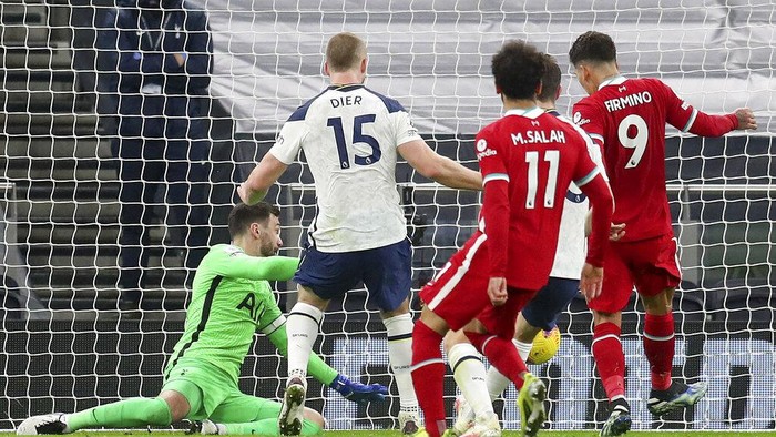 Liverpools Roberto Firmino, right, shoots to score his sides first goal during the English Premier League soccer match between Tottenham Hotspur and Liverpool at the Tottenham Hotspur Stadium in London, Thursday, Jan. 28, 2021. (Catherine Ivill/Pool via AP)