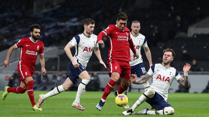 LONDON, ENGLAND - JANUARY 28: Roberto Firmino of Liverpool is tackled by Joe Rodon of Tottenham Hotspur during the Premier League match between Tottenham Hotspur and Liverpool at Tottenham Hotspur Stadium on January 28, 2021 in London, England. Sporting stadiums around the UK remain under strict restrictions due to the Coronavirus Pandemic as Government social distancing laws prohibit fans inside venues resulting in games being played behind closed doors. (Photo by Catherine Ivill/Getty Images)