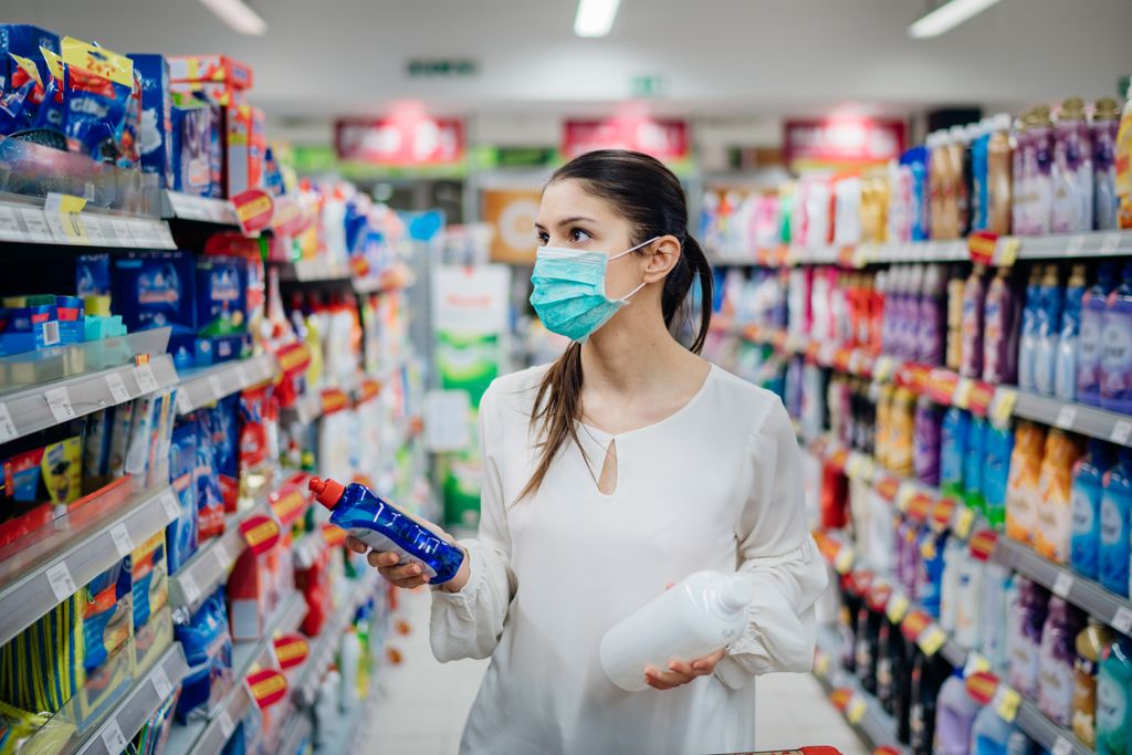 Woman wearing protective mask preparing for virus pandemic spread quarantine.Hygiene, cleaning and disinfection products.Preventive measures and protection.Supply shopping during the epidemic.