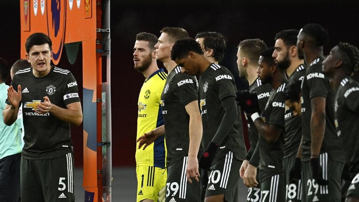 Manchester Uniteds Harry Maguire, left, applauds before the English Premier League soccer match between Arsenal and Manchester United at the Emirates stadium in London, Saturday, Jan. 30, 2021. (Andy Rain/Pool via AP)