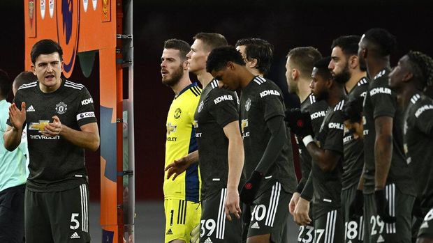 Manchester United's Harry Maguire, left, applauds before the English Premier League soccer match between Arsenal and Manchester United at the Emirates stadium in London, Saturday, Jan. 30, 2021. (Andy Rain/Pool via AP)
