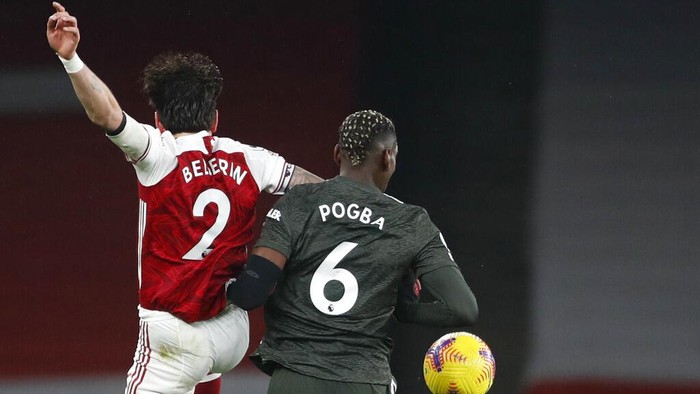 Arsenals Hector Bellerin, left, duels for the ball with Manchester Uniteds Paul Pogba during the English Premier League soccer match between Arsenal and Manchester United at the Emirates stadium in London, Saturday, Jan. 30, 2021. (AP Photo/Alastair Grant, Pool)