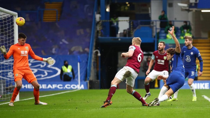 LONDON, ENGLAND - JANUARY 31: Marcos Alonso of Chelsea scores their sides second goal past Nick Pope of Burnley during the Premier League match between Chelsea and Burnley at Stamford Bridge on January 31, 2021 in London, England. Sporting stadiums around the UK remain under strict restrictions due to the Coronavirus Pandemic as Government social distancing laws prohibit fans inside venues resulting in games being played behind closed doors. (Photo by Julian Finney/Getty Images)