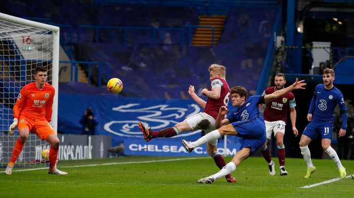 LONDON, ENGLAND - JANUARY 31: Marcos Alonso of Chelsea scores their sides second goal past Nick Pope of Burnley during the Premier League match between Chelsea and Burnley at Stamford Bridge on January 31, 2021 in London, England. Sporting stadiums around the UK remain under strict restrictions due to the Coronavirus Pandemic as Government social distancing laws prohibit fans inside venues resulting in games being played behind closed doors. (Photo by Andrew Couldridge - Pool/Getty Images)