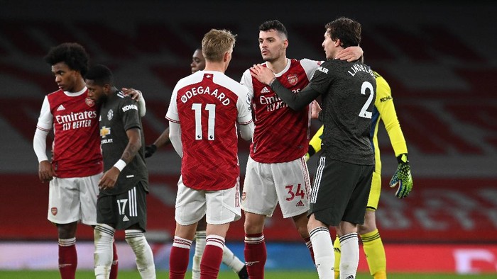 LONDON, ENGLAND - JANUARY 30: Granit Xhaka and Martin Odegaard of Arsenal interact with Victor Lindelof of Manchester United after the Premier League match between Arsenal and Manchester United at Emirates Stadium on January 30, 2021 in London, England. Sporting stadiums around the UK remain under strict restrictions due to the Coronavirus Pandemic as Government social distancing laws prohibit fans inside venues resulting in games being played behind closed doors. (Photo by Andy Rain - Pool/Getty Images)
