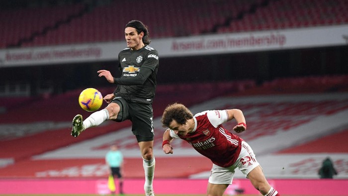 LONDON, ENGLAND - JANUARY 30: Edinson Cavani of Manchester United  is challenged by David Luiz of Arsenal  during the Premier League match between Arsenal and Manchester United at Emirates Stadium on January 30, 2021 in London, England. Sporting stadiums around the UK remain under strict restrictions due to the Coronavirus Pandemic as Government social distancing laws prohibit fans inside venues resulting in games being played behind closed doors. (Photo by Shaun Botterill/Getty Images)