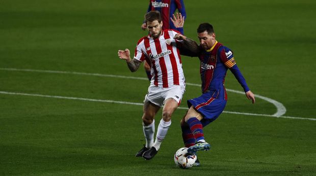 Barcelona's Lionel Messi, right, fights for the ball with Athletic Bilbao's Inigo Martinez during the Spanish La Liga soccer match between FC Barcelona and Athletic Bilbao at the Camp Nou stadium in Barcelona, Spain, Sunday, Jan. 31, 2021. (AP Photo/Joan Monfort)