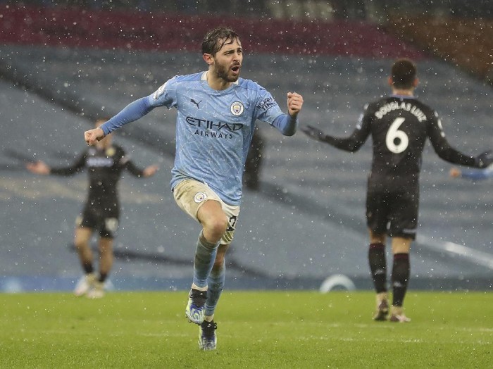 Manchester City's Bernardo Silva celebrates after scoring his side's opening goal during the English Premier League soccer match between Manchester City and Aston Villa at the Etihad Stadium in Manchester, England, Wednesday, Jan.20, 2021. ((Martin Rickett/Pool via AP)