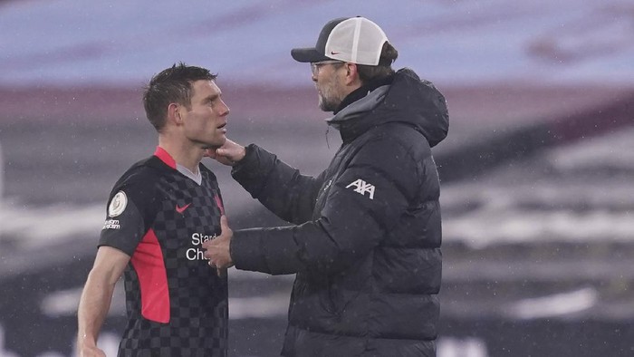Liverpools James Milner, left, talks to Liverpools manager Jurgen Klopp after he was replaced by Liverpools Curtis Jones during the English Premier League match between West Ham and Liverpool at the the London Stadium in London, Sunday, Jan. 31, 2021. (John Walton/Pool via AP)