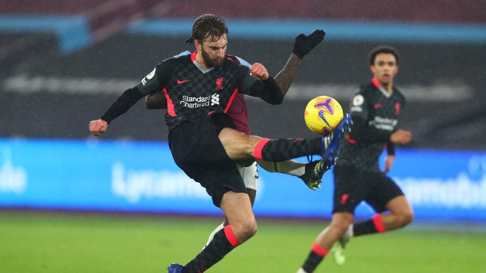 LONDON, ENGLAND - JANUARY 31: Nathaniel Phillips of Liverpool clears the ball whilst under pressure from Michail Antonio of West Ham United during the Premier League match between West Ham United and Liverpool at London Stadium on January 31, 2021 in London, England. Sporting stadiums around the UK remain under strict restrictions due to the Coronavirus Pandemic as Government social distancing laws prohibit fans inside venues resulting in games being played behind closed doors. (Photo by Clive Rose/Getty Images)