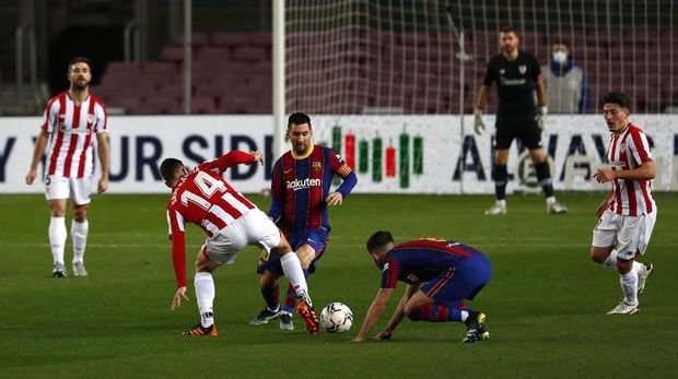 Barcelona's Lionel Messi, center, fights for the ball with Athletic Bilbao's Dani Garcia during the Spanish La Liga soccer match between FC Barcelona and Athletic Bilbao at the Camp Nou stadium in Barcelona, Spain, Sunday, Jan. 31, 2021. (AP Photo/Joan Monfort)