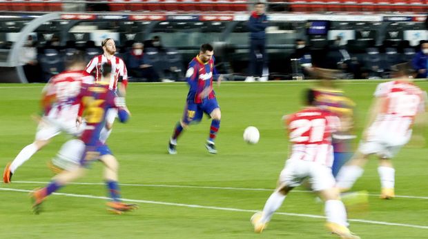 In this photo taken with slow shutter speed, Barcelona's Lionel Messi, center, runs with the ball during the Spanish La Liga soccer match between FC Barcelona and Athletic Bilbao at the Camp Nou stadium in Barcelona, Spain, Sunday, Jan. 31, 2021. (AP Photo/Joan Monfort)