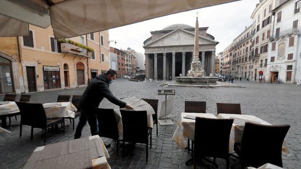 A cafe employee prepares tables near the Pantheon after the coronavirus disease (COVID-19) restrictions were eased in Lazio region, Rome, Italy, February 1, 2021. REUTERS/Yara Nardi