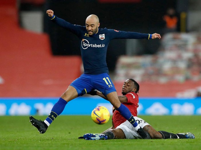 MANCHESTER, ENGLAND - FEBRUARY 02: Aaron Wan-Bissaka of Manchester United tackles Nathan Redmond of Southampton  during the Premier League match between Manchester United and Southampton at Old Trafford on February 02, 2021 in Manchester, England. Sporting stadiums around the UK remain under strict restrictions due to the Coronavirus Pandemic as Government social distancing laws prohibit fans inside venues resulting in games being played behind closed doors. (Photo by Phil Noble - Pool/Getty Images)