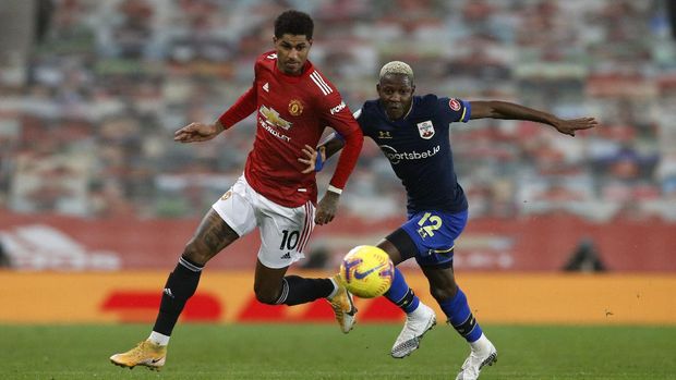 Manchester United's Marcus Rashford, left, duels for the ball with Southampton's Moussa Djenepo during the English Premier League soccer match between Manchester United and Southampton, at the Old Trafford stadium in Manchester, England, Tuesday, Feb. 2, 2021. (Phil Noble/Pool via AP)