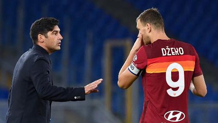 AS Romas Portuguese head coach Paulo Fonseca (L) talks with AS Romas Bosnian forward Edin Dzeko during the Italian Serie A football match Roma vs Benevento on October 18, 2020 at Olympic stadium in Rome. (Photo by Tiziana FABI / AFP)