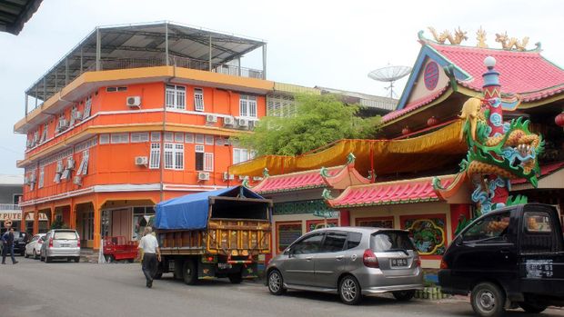 Singkawang, West Kalimantan, Indonesia  - August 29, 2013:  Confucian temple and traffic on the road of the Singkawang city, West Kalimantan, Indonesia.