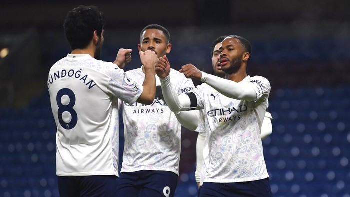 Manchester Citys Raheem Sterling, right, celebrates with teammates after scoring his sides second goal during the English Premier League soccer match between Burnley and Manchester City at Turf Moor stadium in Burnley, England, Wednesday, Feb. 3, 2021. (Gareth Copley/Pool via AP)