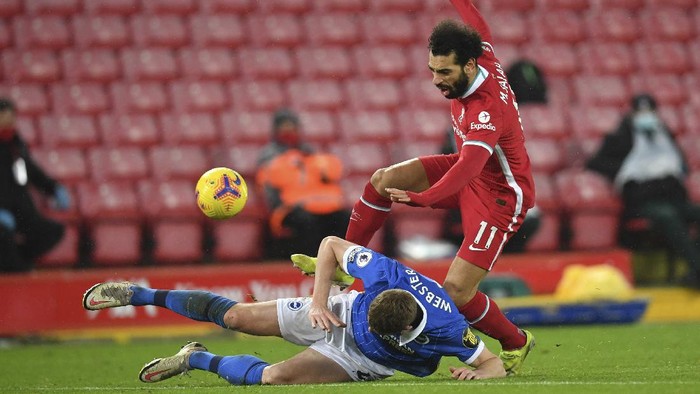 Liverpools Mohamed Salah, right, is tackled by Brightons Adam Webster during the English Premier League soccer match between Liverpool and Brighton at Anfield stadium, in Liverpool, England, Wednesday, Feb. 3, 2021. (Paul Ellis/Pool via AP)