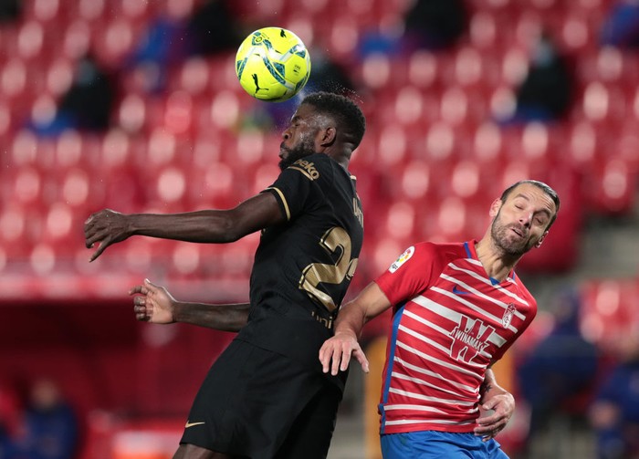 GRANADA, SPAIN - JANUARY 09: Samuel Umtiti of Barcelona wins a header over Roberto Soldado of Granada during the La Liga Santander match between Granada CF and FC Barcelona at Estadio Nuevo Los Carmenes on January 09, 2021 in Granada, Spain. Sporting stadiums around Spain remain under strict restrictions due to the Coronavirus Pandemic as Government social distancing laws prohibit fans inside venues resulting in games being played behind closed doors. (Photo by Gonzalo Arroyo Moreno/Getty Images)