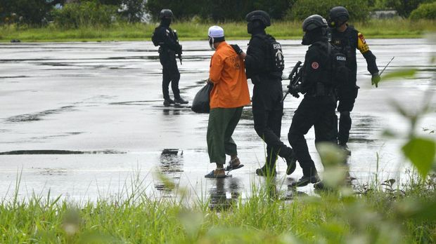 Tim gabungan Detasemen Khusus (Densus) 88 Antiteror Mabes Polri dan Brimob Polda Sulsel menggiring tersangka teroris saat akan diberangkatkan ke Jakarta di Bandara lama Sultan Hasanuddin, Kabupaten Maros, Sulawesi Selatan, Kamis (4/2/2021). Sebanyak 19 tersangka kasus terorisme jaringan Jamaah Ansharut Daulah (JAD) yang ditangkap Tim Densus 88 Antiteror di Makassar tersebut diterbangkan ke Jakarta untuk menjalani pemeriksaan lanjutan. ANTARA FOTO/Abriawan Abhe/aww.