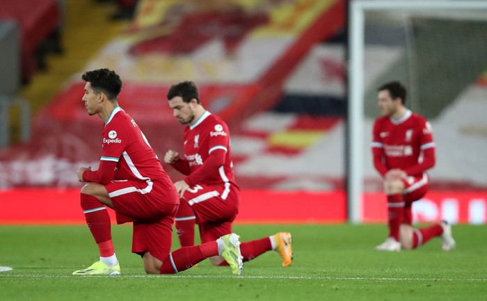 LIVERPOOL, ENGLAND - FEBRUARY 03: Roberto Firminho of Liverpool takes a knee in support of the Black Lives Matter movement prior to the Premier League match between Liverpool and Brighton & Hove Albion at Anfield on February 03, 2021 in Liverpool, England. Sporting stadiums around the UK remain under strict restrictions due to the Coronavirus Pandemic as Government social distancing laws prohibit fans inside venues resulting in games being played behind closed doors. (Photo by Clive Brunskill/Getty Images)