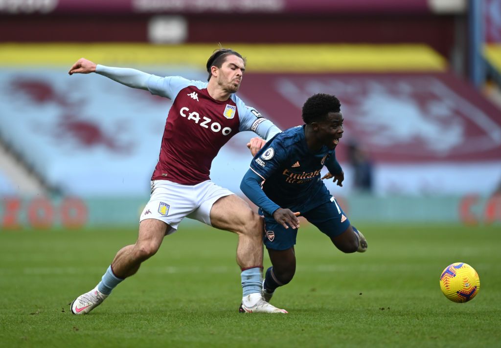 BIRMINGHAM, ENGLAND - FEBRUARY 06: Bukayo Saka of Arsenal is tackled by Jack Grealish of Aston Villa during the Premier League match between Aston Villa and Arsenal at Villa Park on February 06, 2021 in Birmingham, England. Sporting stadiums around the UK remain under strict restrictions due to the Coronavirus Pandemic as Government social distancing laws prohibit fans inside venues resulting in games being played behind closed doors. (Photo by Shaun Botterill/Getty Images)