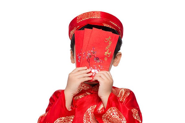 Membagikan angpao kepada anggota keluarga yang belum menikah, terutama anak kecil / foto: istockphoto.com