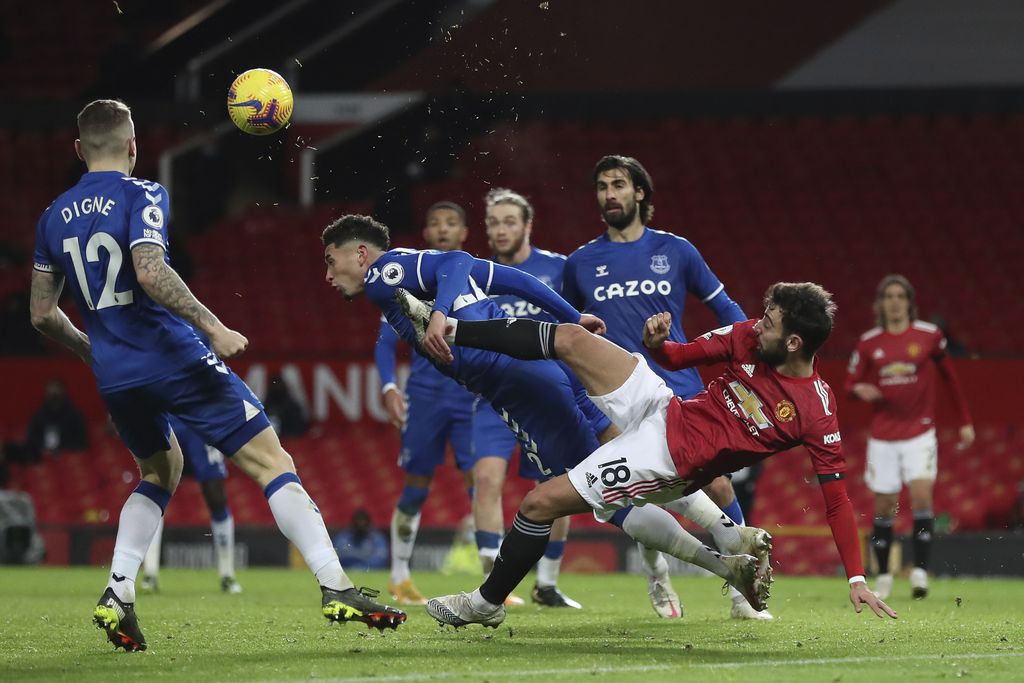 Manchester United's Bruno Fernandes, right, challenges for the ball with Everton's Ben Godfrey during an English Premier League soccer match between Manchester United and Everton at the Old Trafford stadium in Manchester, England, Saturday Feb. 6, 2021. (Martin Rickett/Pool via AP)