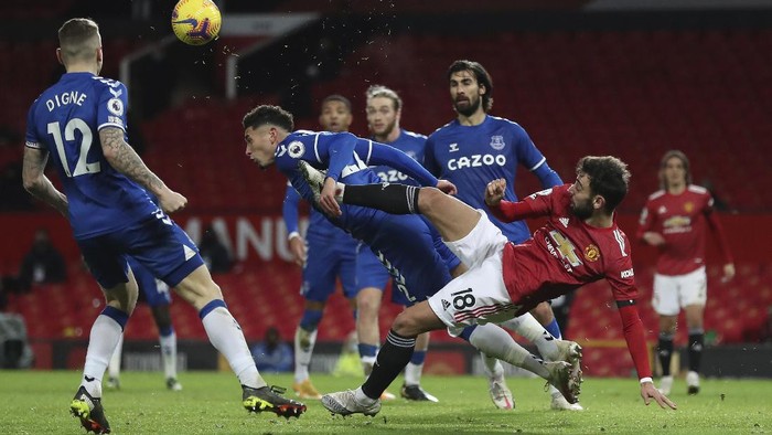 Manchester Uniteds Bruno Fernandes, right, challenges for the ball with Evertons Ben Godfrey during an English Premier League soccer match between Manchester United and Everton at the Old Trafford stadium in Manchester, England, Saturday Feb. 6, 2021. (Martin Rickett/Pool via AP)