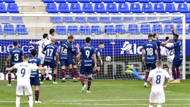 Real Madrid's Raphael Varane, right, scores his side's second goal during the Spanish La Liga soccer match between Huesca and Real Madrid at El Alcoraz stadium in Huesca, Spain, Saturday, Feb. 6, 2021. (AP Photo/Alvaro Barrientos)
