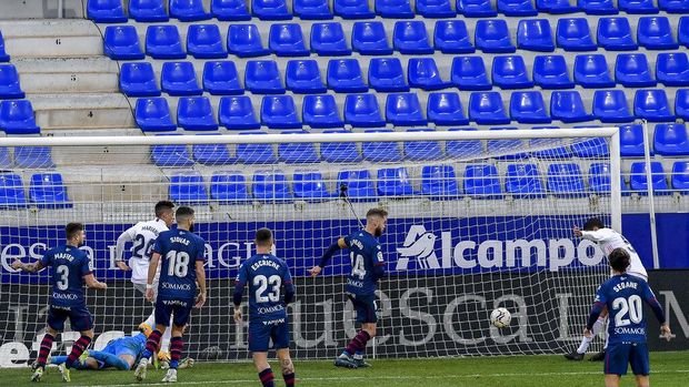 Real Madrid's Raphael Varane, right, scores his side's second goal during the Spanish La Liga soccer match between Huesca and Real Madrid at El Alcoraz stadium in Huesca, Spain, Saturday, Feb. 6, 2021. (AP Photo/Alvaro Barrientos)
