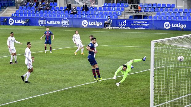 Real Madrid's Raphael Varane, right, scores his side's second goal during the Spanish La Liga soccer match between Huesca and Real Madrid at El Alcoraz stadium in Huesca, Spain, Saturday, Feb. 6, 2021. (AP Photo/Alvaro Barrientos)