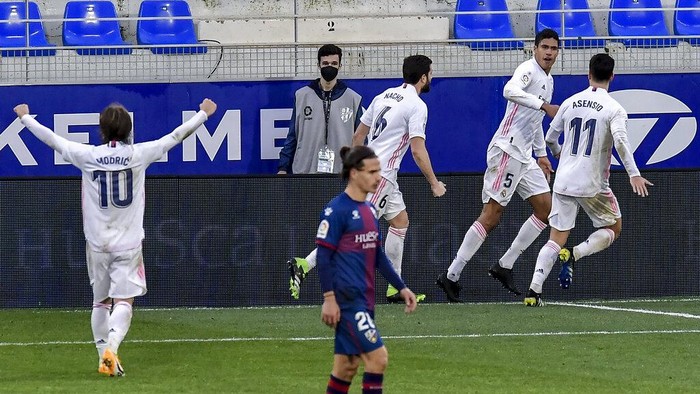 Real Madrids Raphael Varane, right, celebrates after scoring his sides second goal during the Spanish La Liga soccer match between Huesca and Real Madrid at El Alcoraz stadium in Huesca, Spain, Saturday, Feb. 6, 2021. (AP Photo/Alvaro Barrientos)