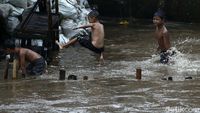 Keceriaan Anak Bukit Duri Bermain di Luapan Sungai Ciliwung