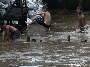 Keceriaan Anak Bukit Duri Bermain di Luapan Sungai Ciliwung Keceriaan Anak Bukit Duri Bermain di Luapan Sungai Ciliwung